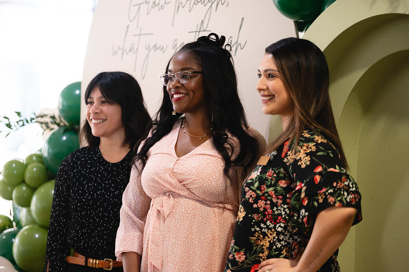 Three female attendees posing for photos at the 2024 Womxn of Color Leadership Conference.