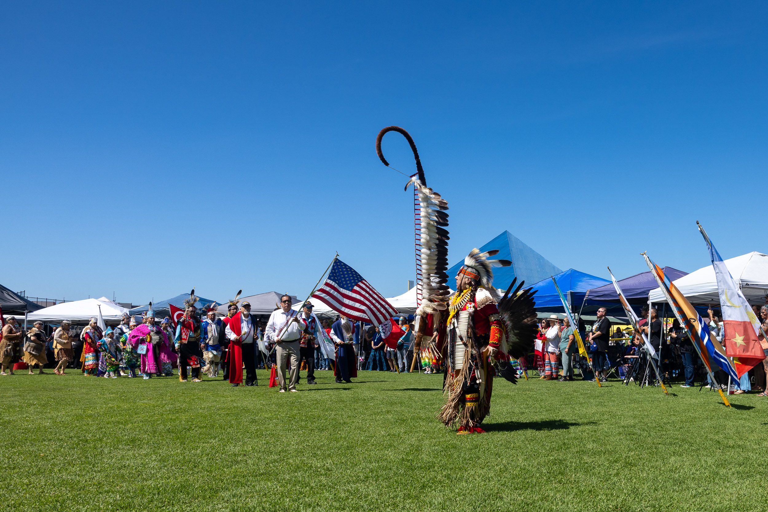 A man holding the Eagle Staff at the 2026 CSULB Pow Wow at Puvungna
