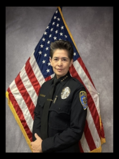 Chief Almaguer headshot in front of American flag.