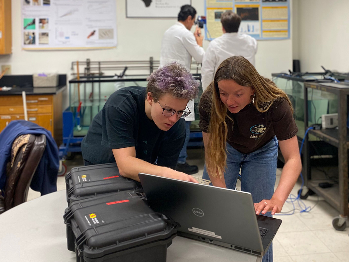 student researchers checking settings on equipment