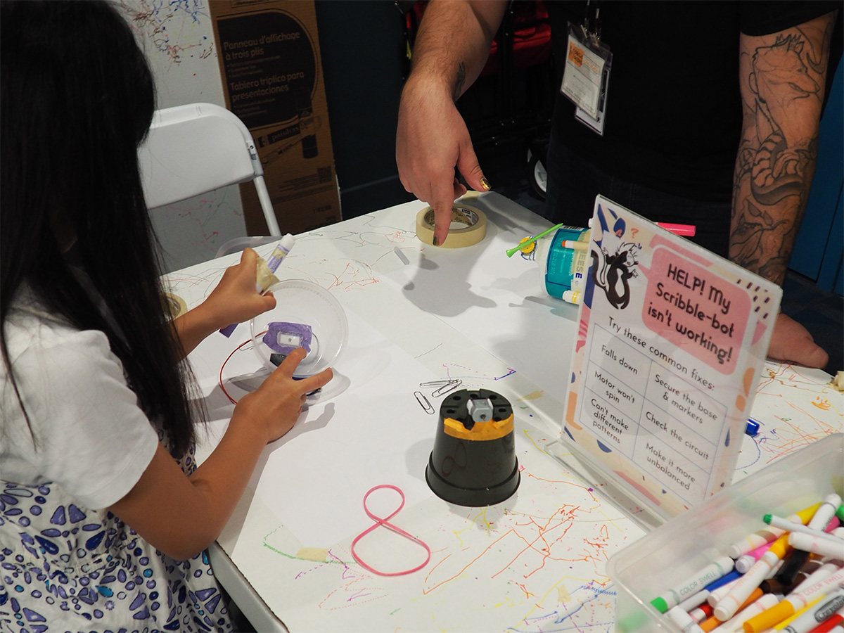 young child using robot to draw scribbles