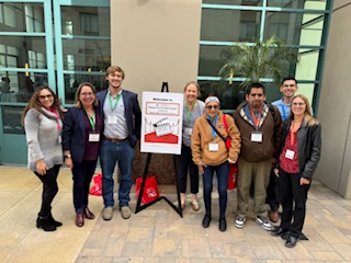 Dr. Sanderson posing for a photo with seven other people from CALTASH 2025 ThinkBeach