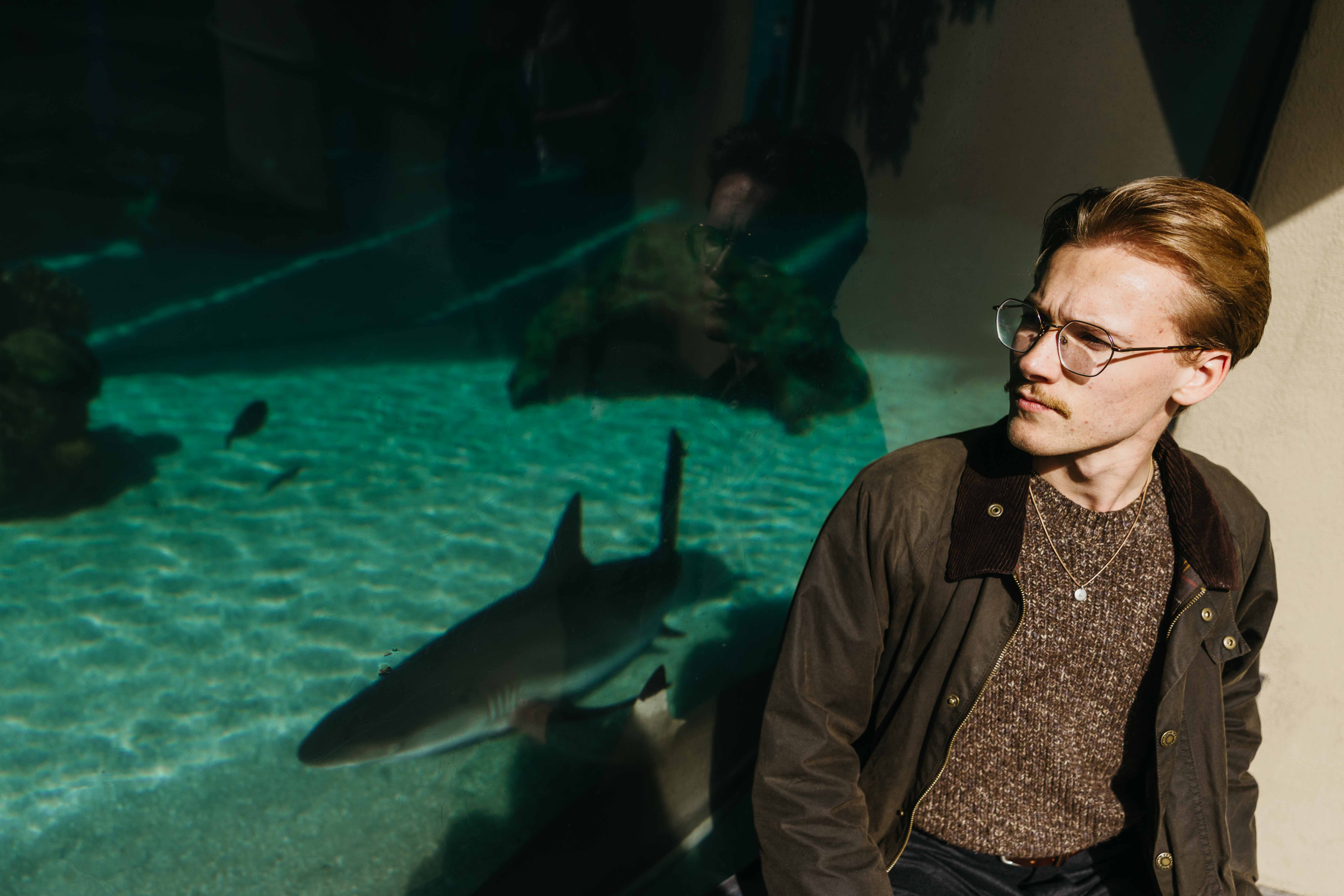 CSULB student researcher Benjamin Krochman by a shark tank