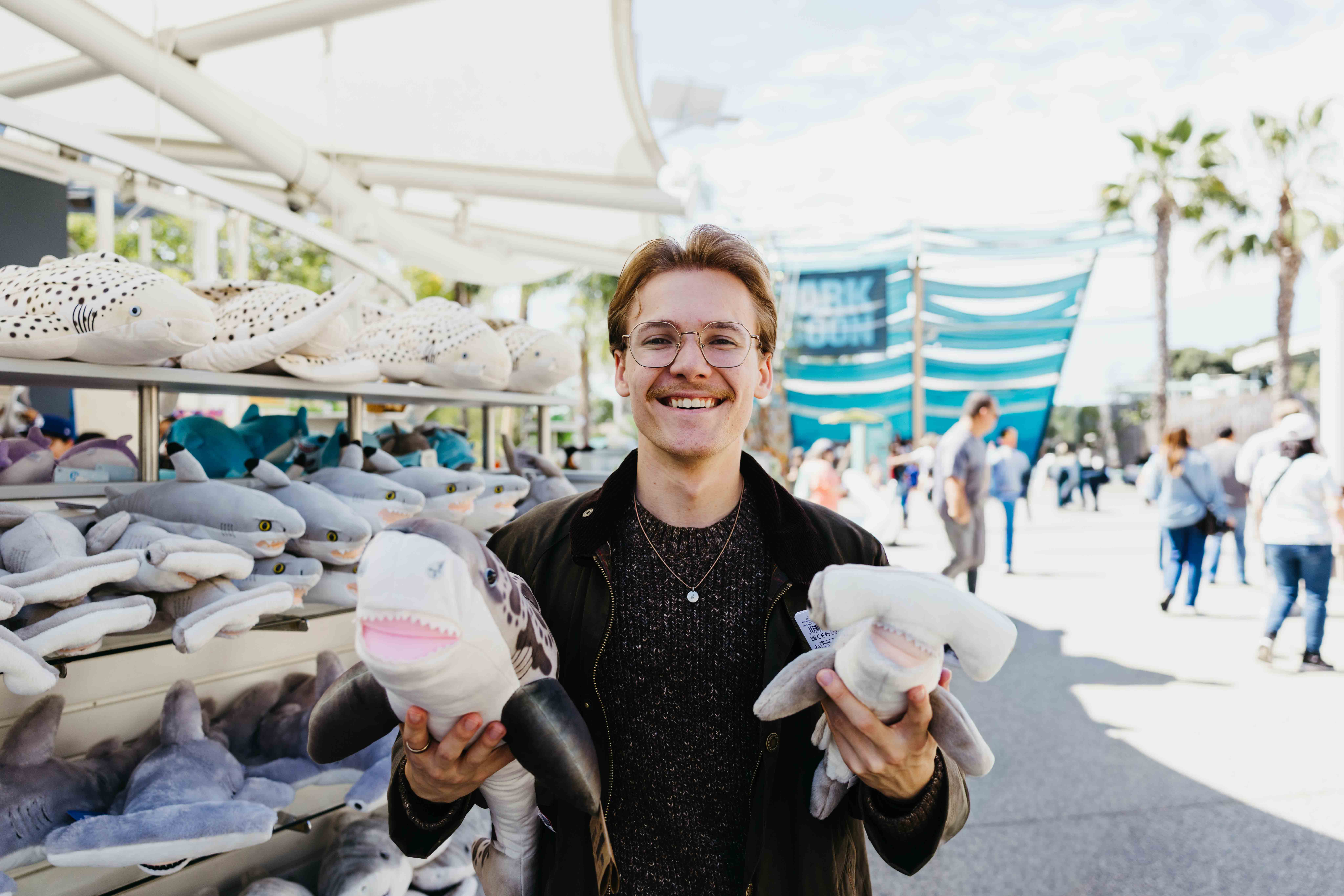 CSULB student researcher Benjamin Krochman with plush sharks