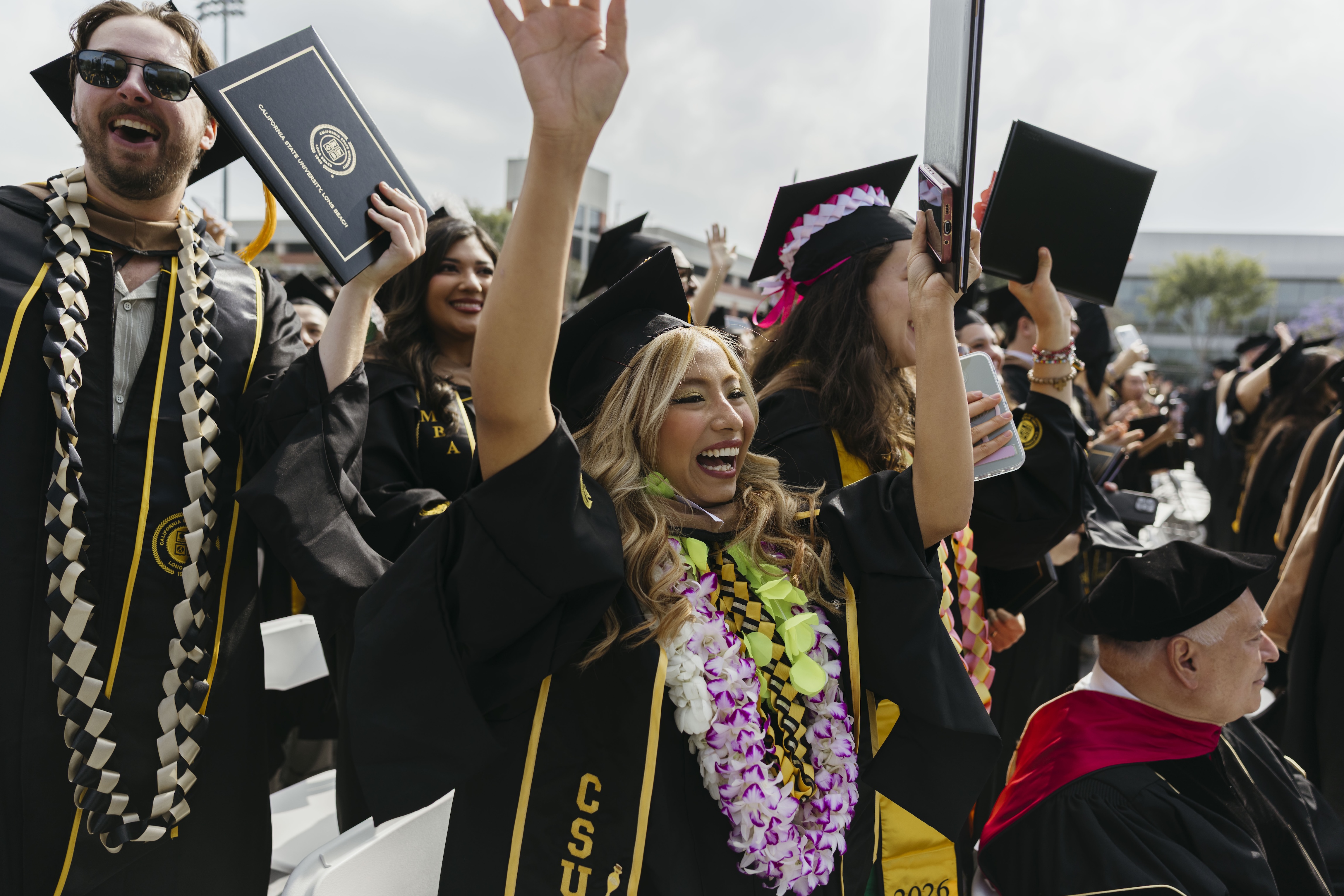 People raise theirs arms in celebration at commencement ceremony