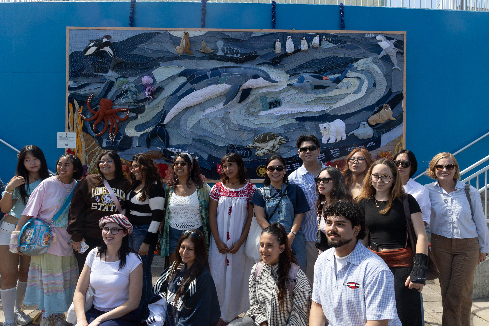 Group poses in front of SeaWorld mural