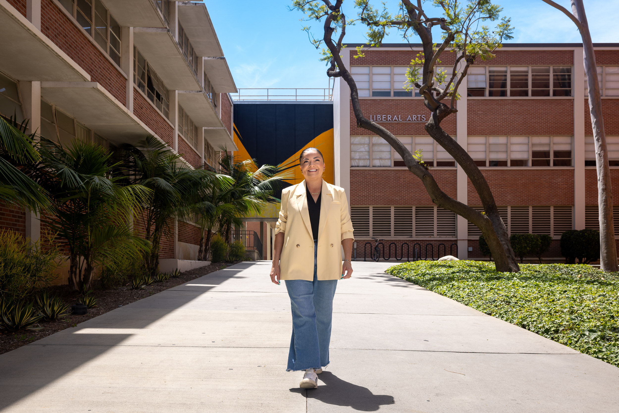 Person walks on campus pathway in front of Liberal Arts building