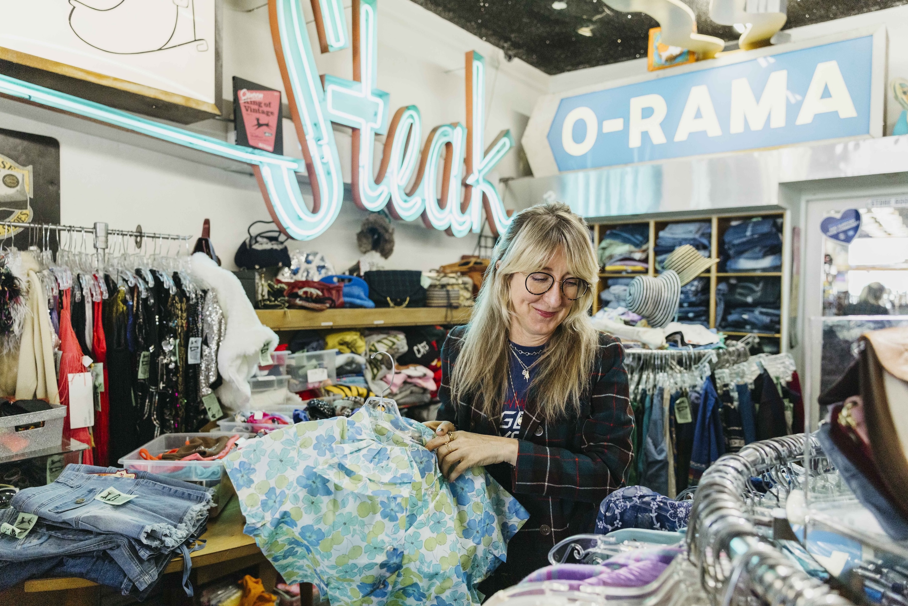 A person sifts through racks inside a vintage clothing store