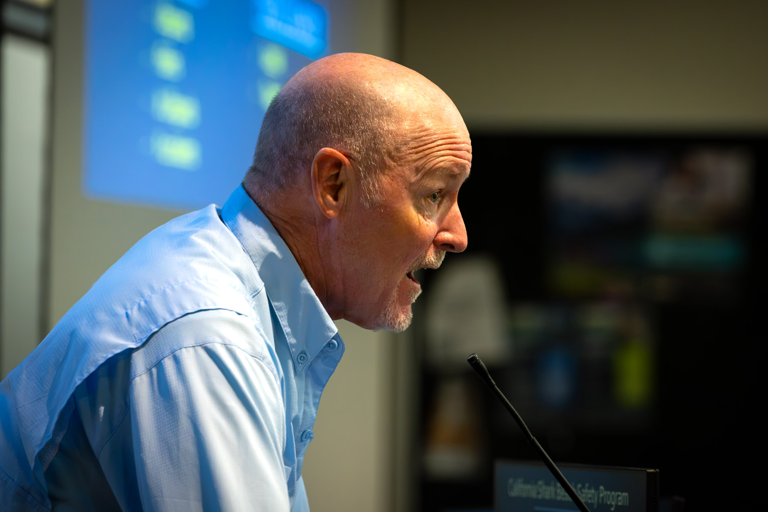 A person speaks into a microphone at a podium
