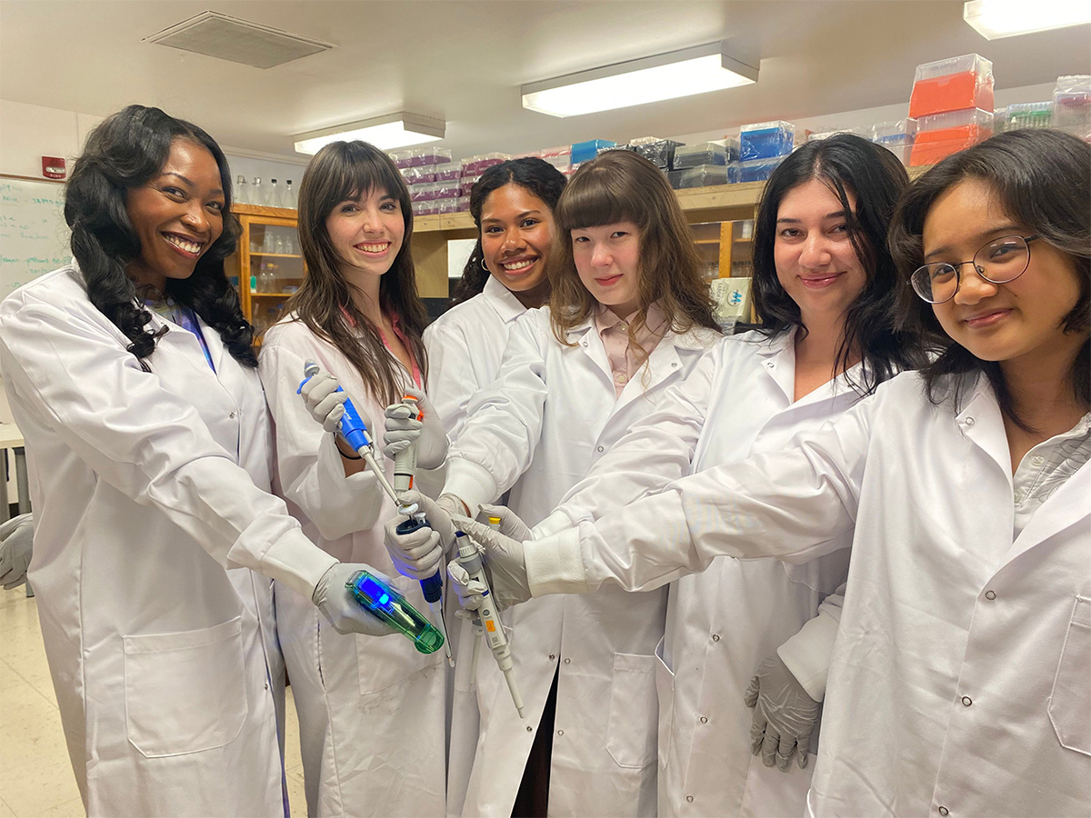 Dr. Lamar Thomas and student researchers posing with pipettors