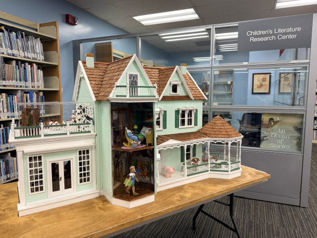 dollhouse in front of bookshelves