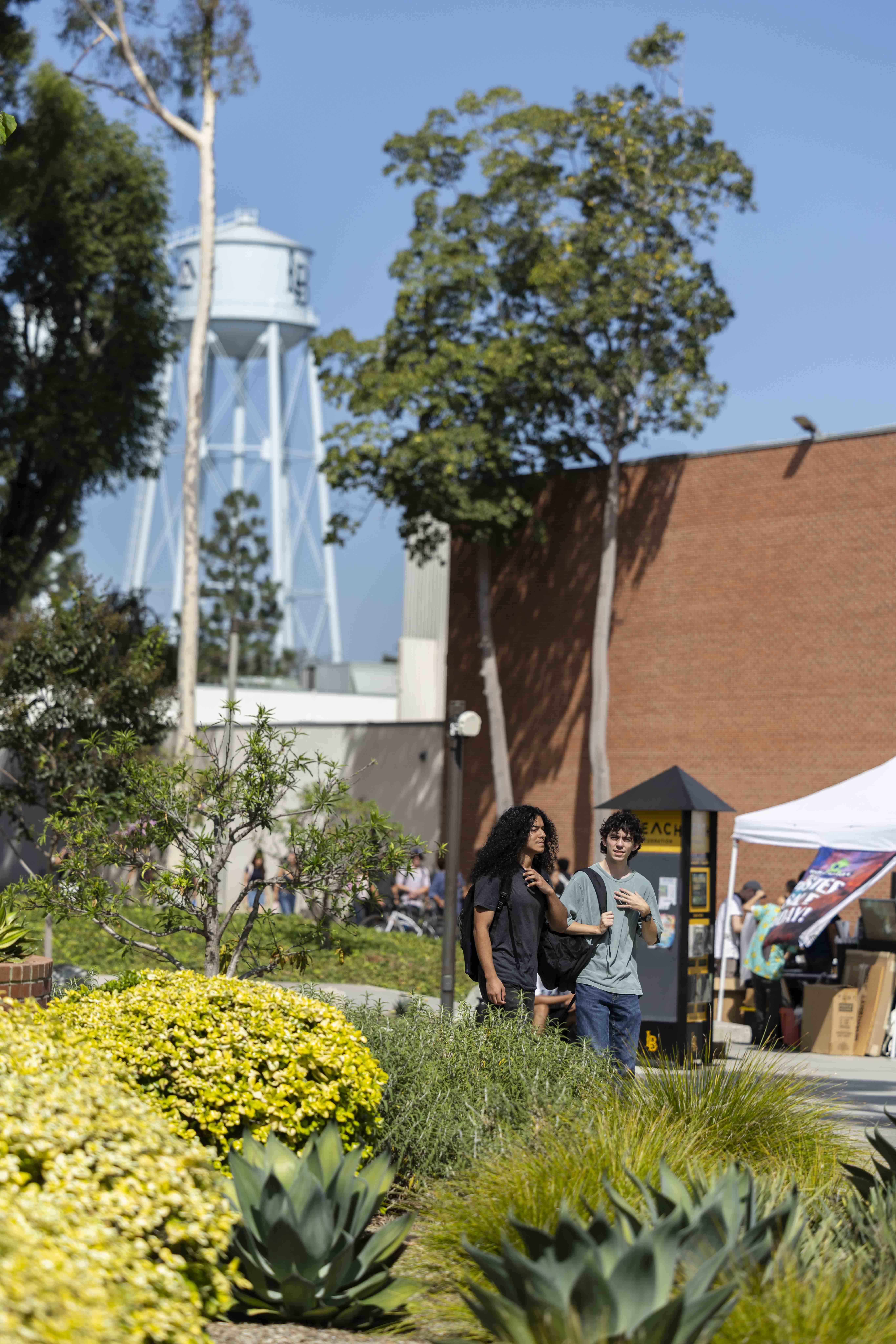Students walking on campus, tower in the background