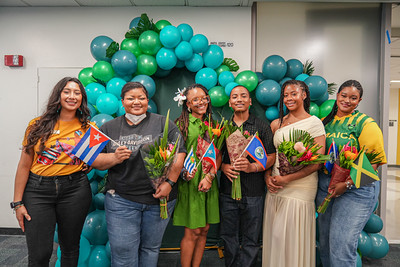 Attendees taking a group photo in front of a blue balloon arch.