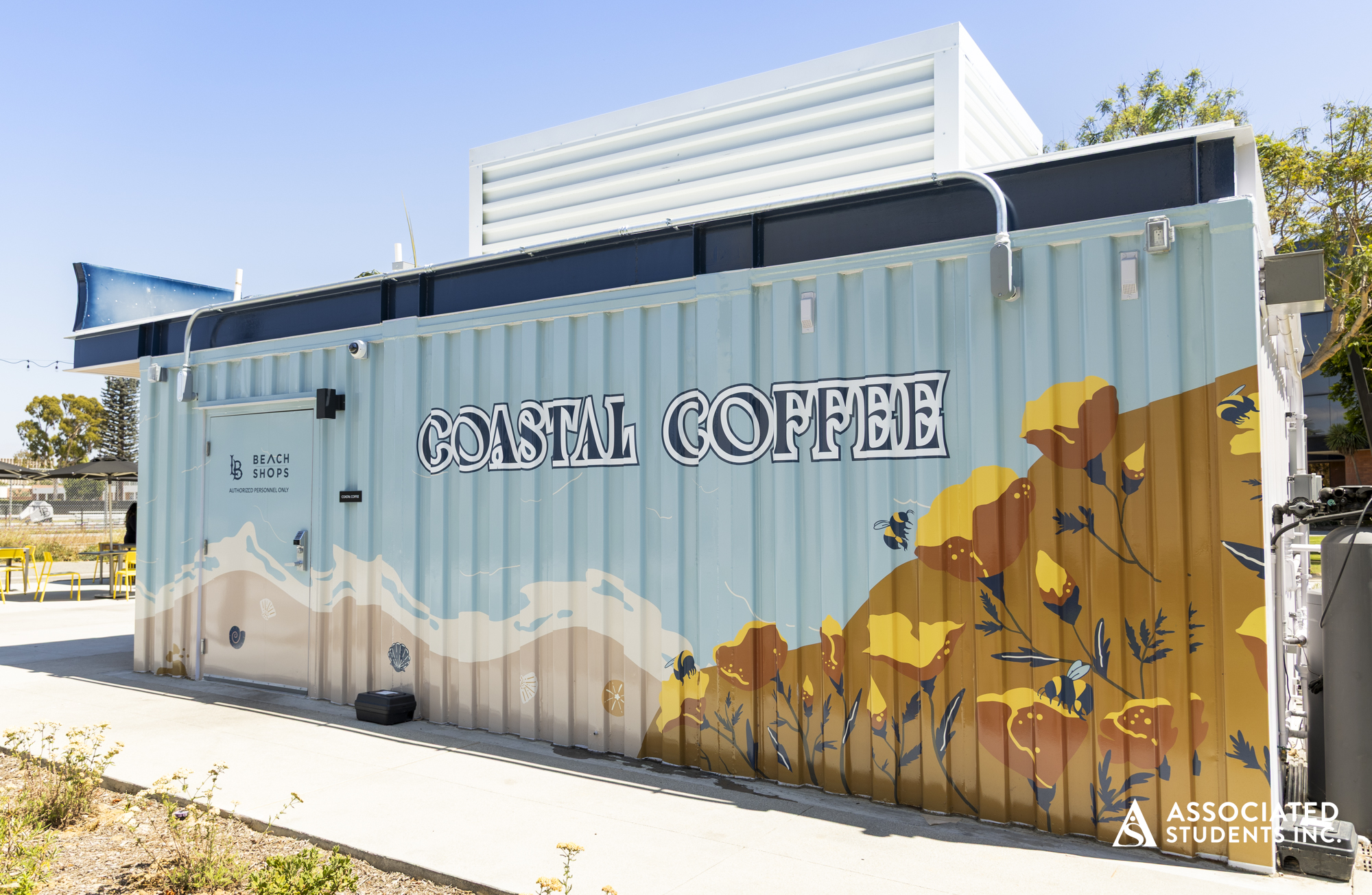 The side of Coastal Coffee showing the name and a coastal design in pastel colors. 