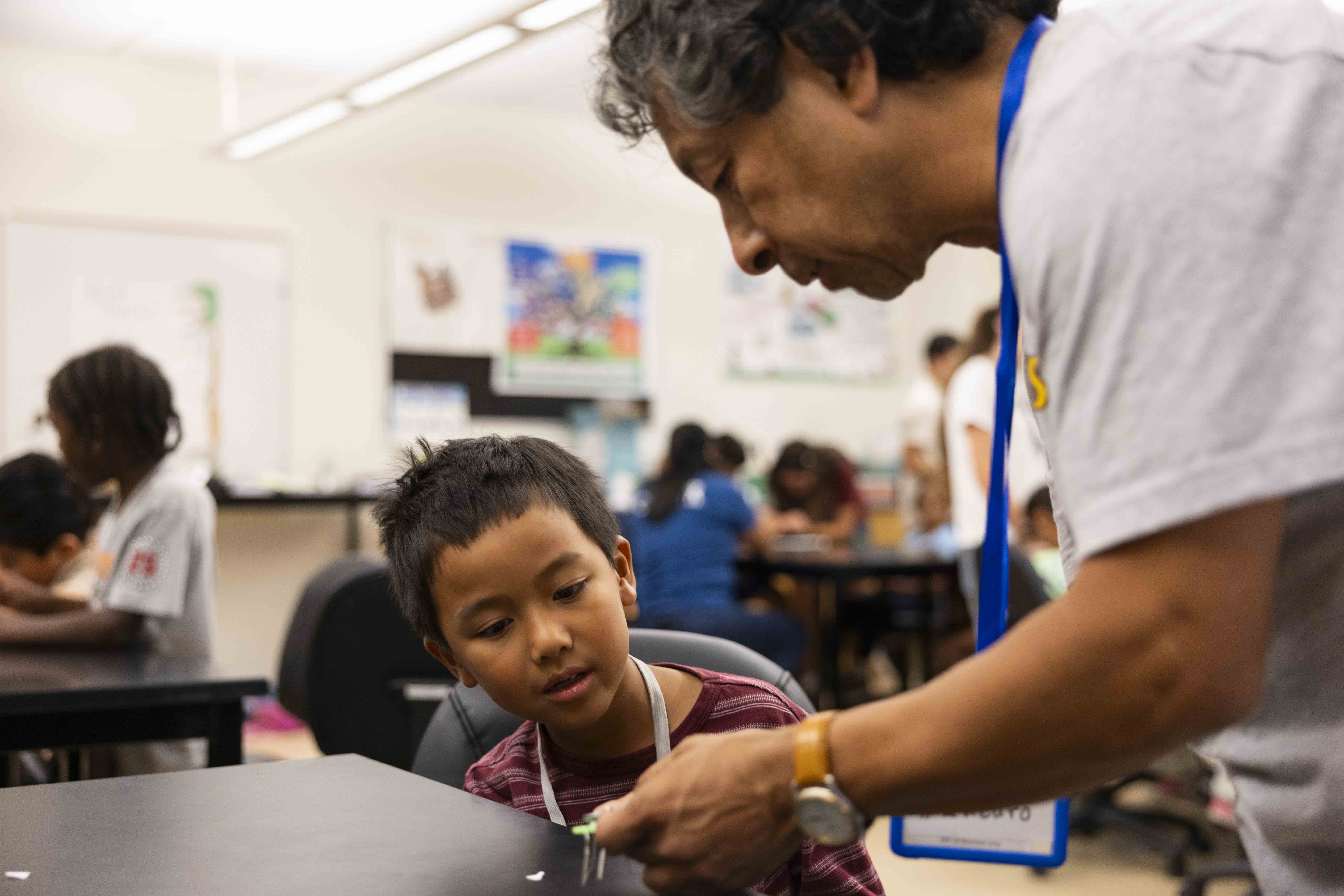 A person helps a child with a hands-on activity