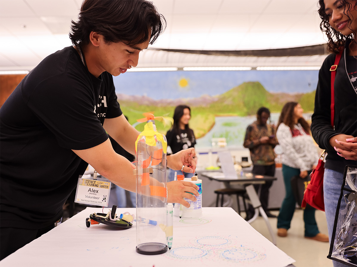 volunteer showing someone how to build a simple robot