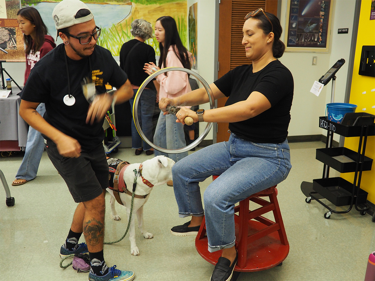 person sitting on a rotating stool and holding a spinning wheel