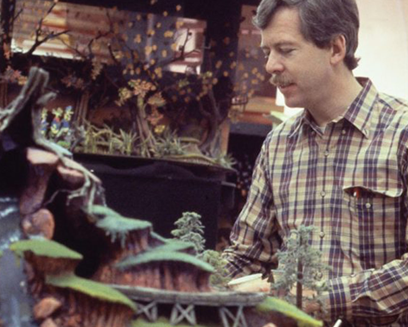 A man looks down at a model version of a theme park ride