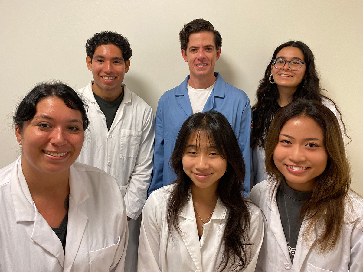 Dr. Michael Carlson and student researchers in lab coats