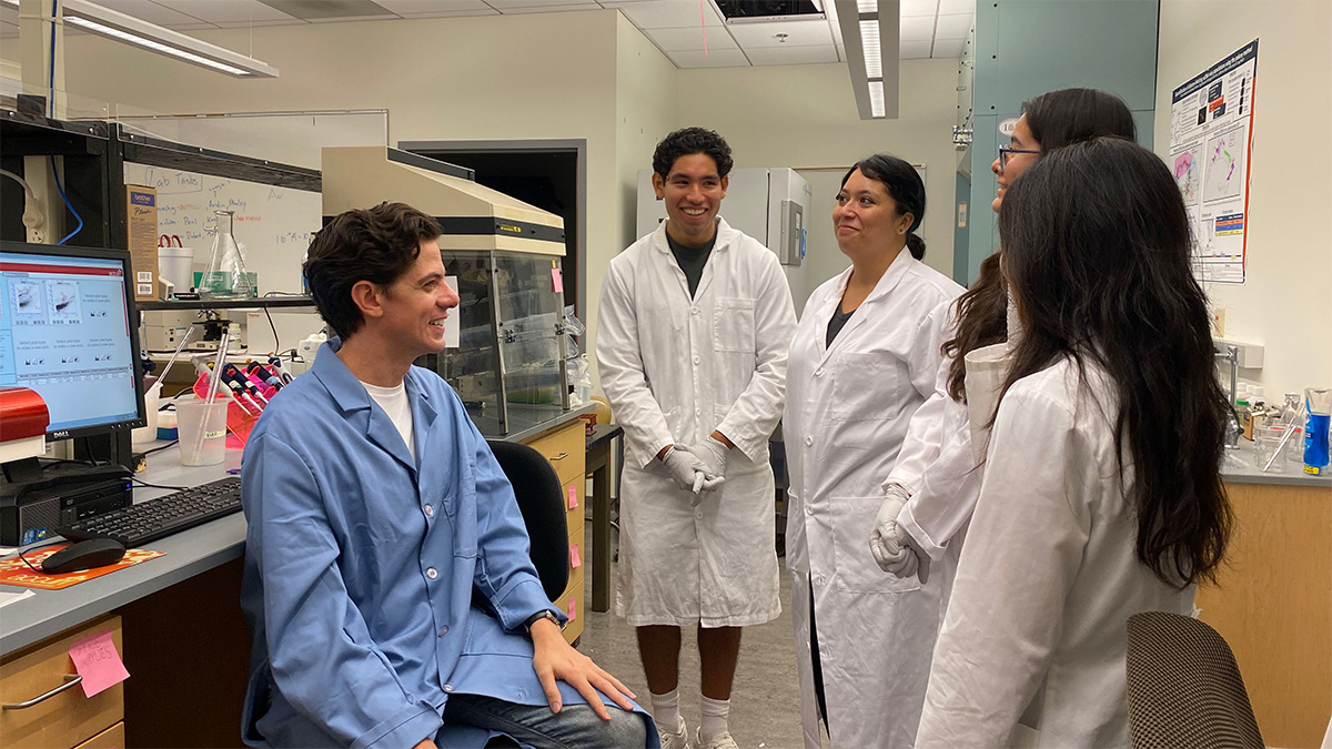 Dr. Michael Carlson and student researchers having a discussion in the lab