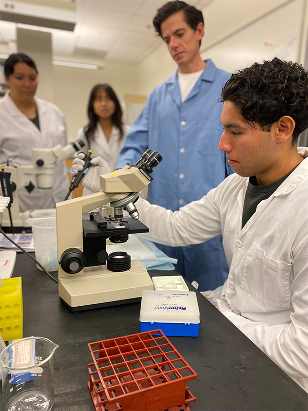 Robert in the lab using a microscope