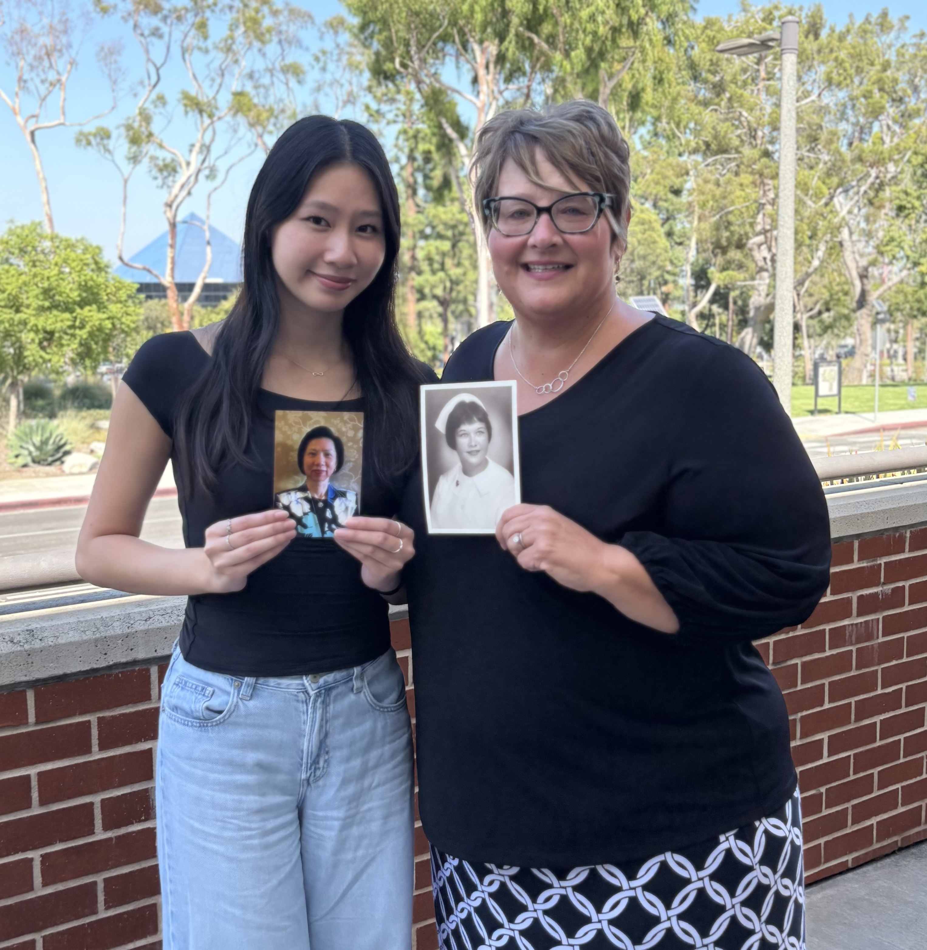Jennifer Fong and Beth Manke hold pictures up 