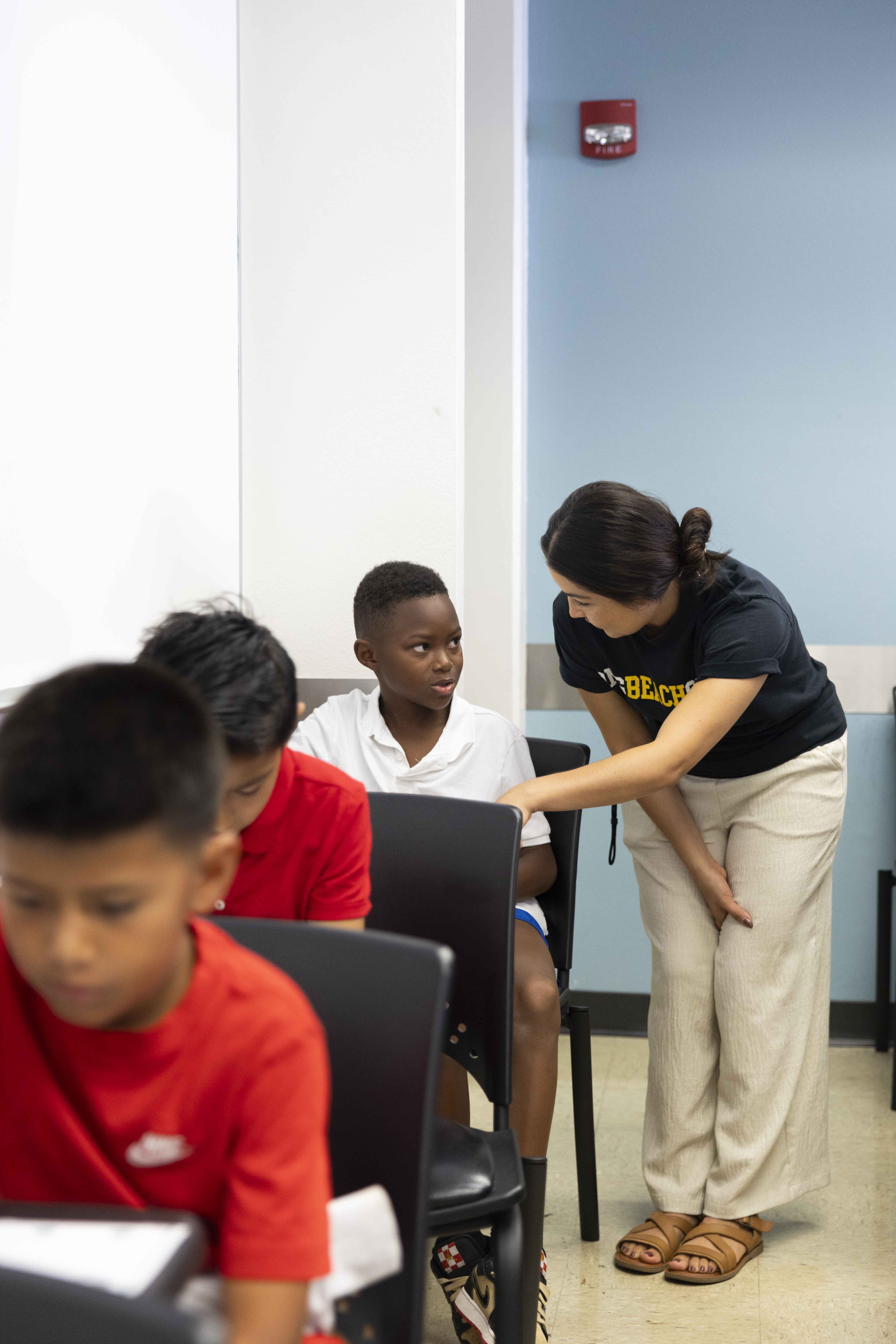 Workshop leader assists children in a classroom