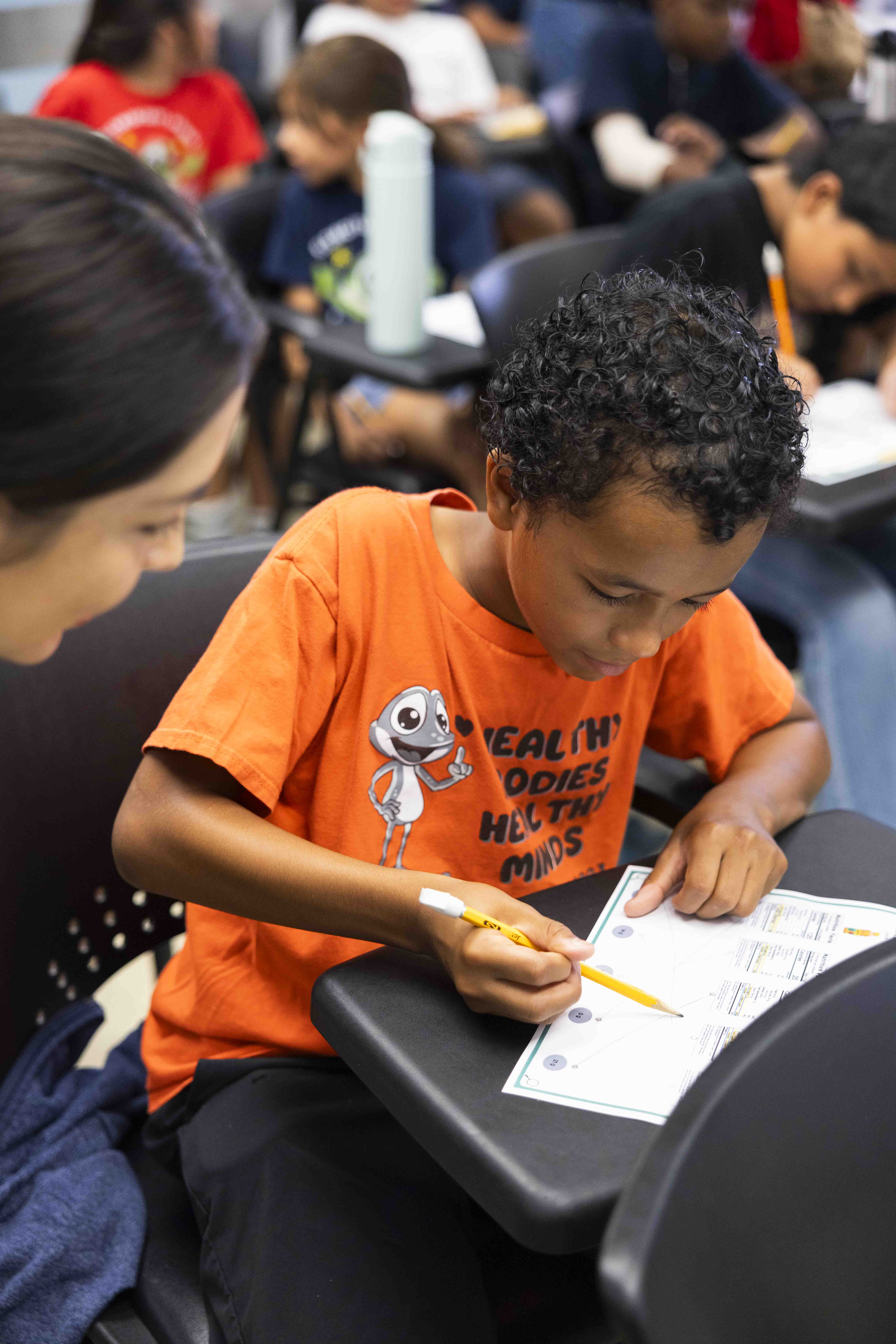 Child completes a nutrition worksheet at a desk