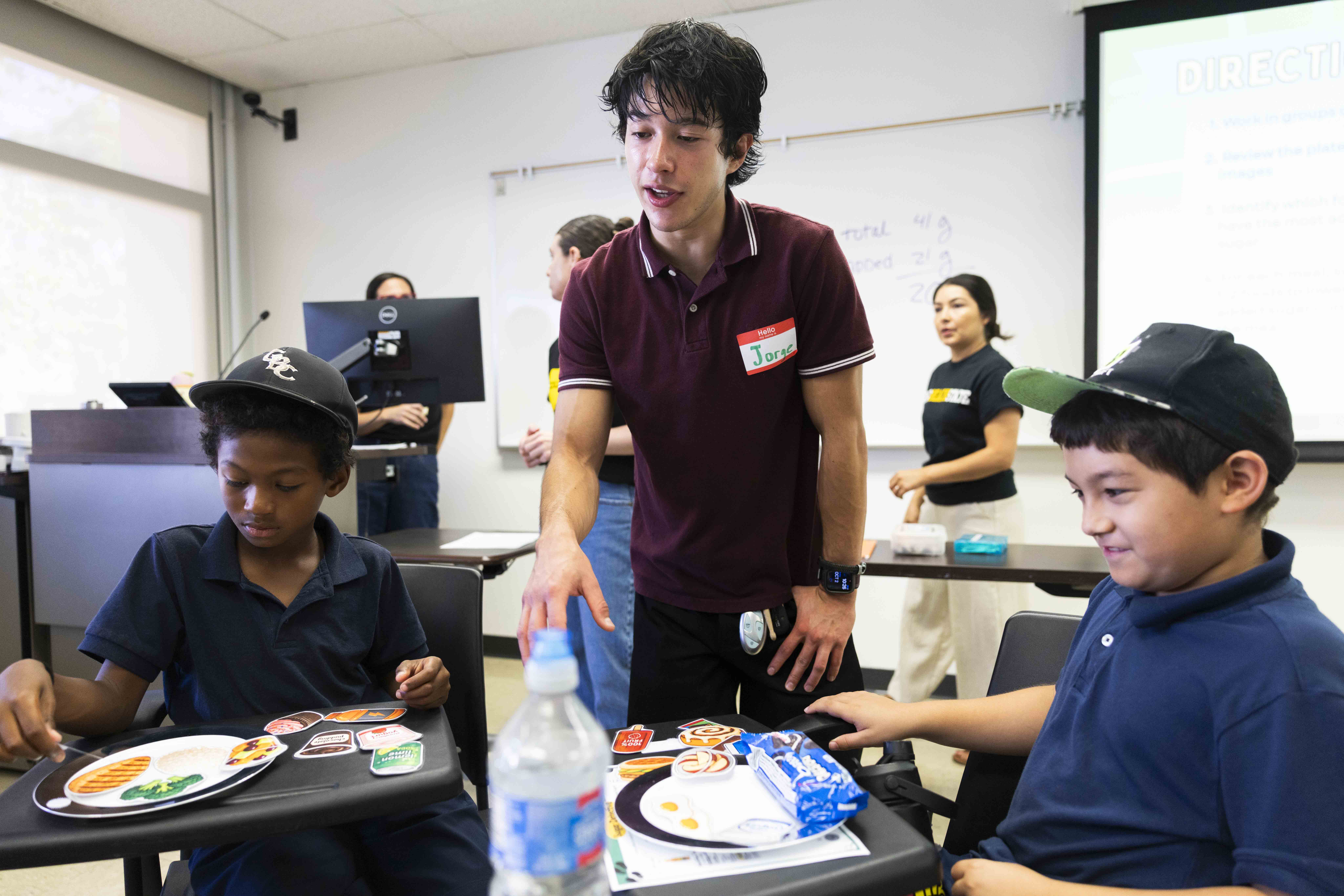 Student facilitator works with children during activity