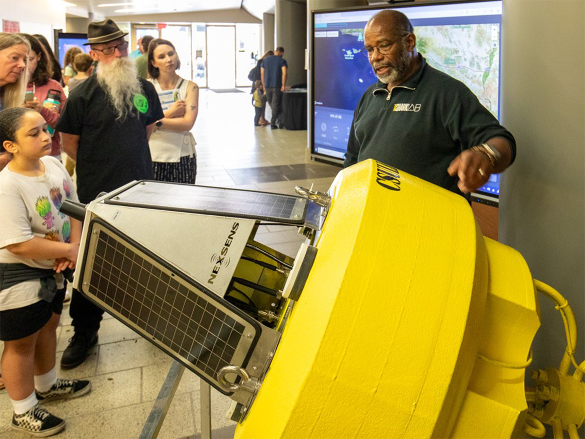 shark lab staff showing off buoy to guests