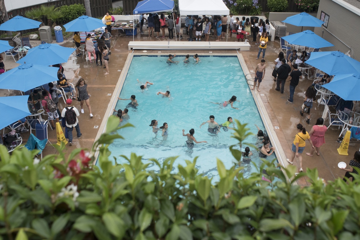 A group of students swims and socializes in the pool