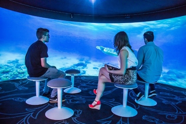 3 people sitting inside a 360 degree theater