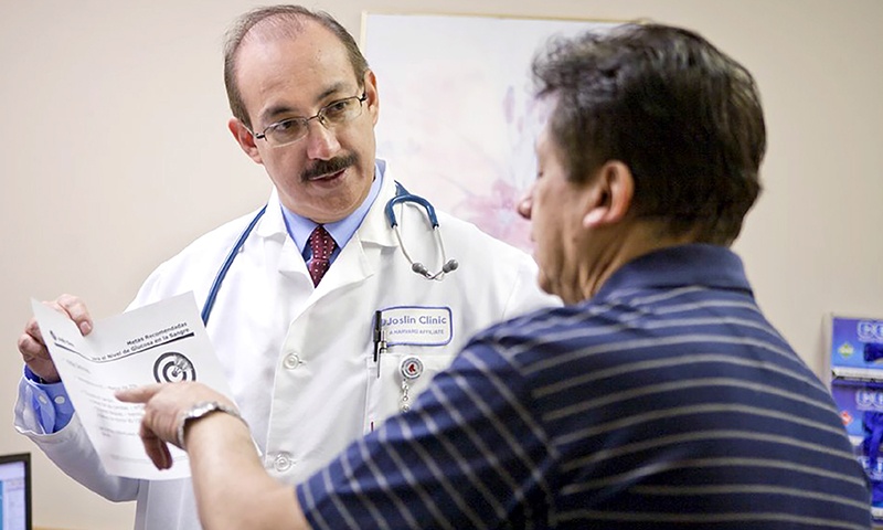 man discussing a piece of paper with a doctor