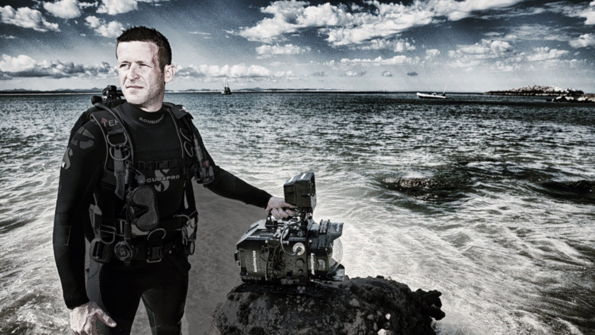 Alumni that is an underwater cinematographer poses with his camera.