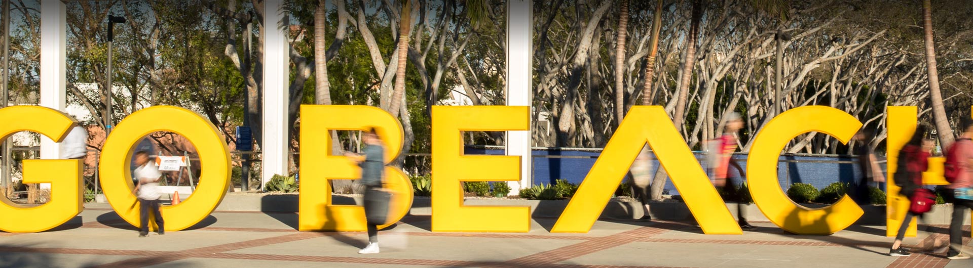 Students walking pass the "go beach" sign