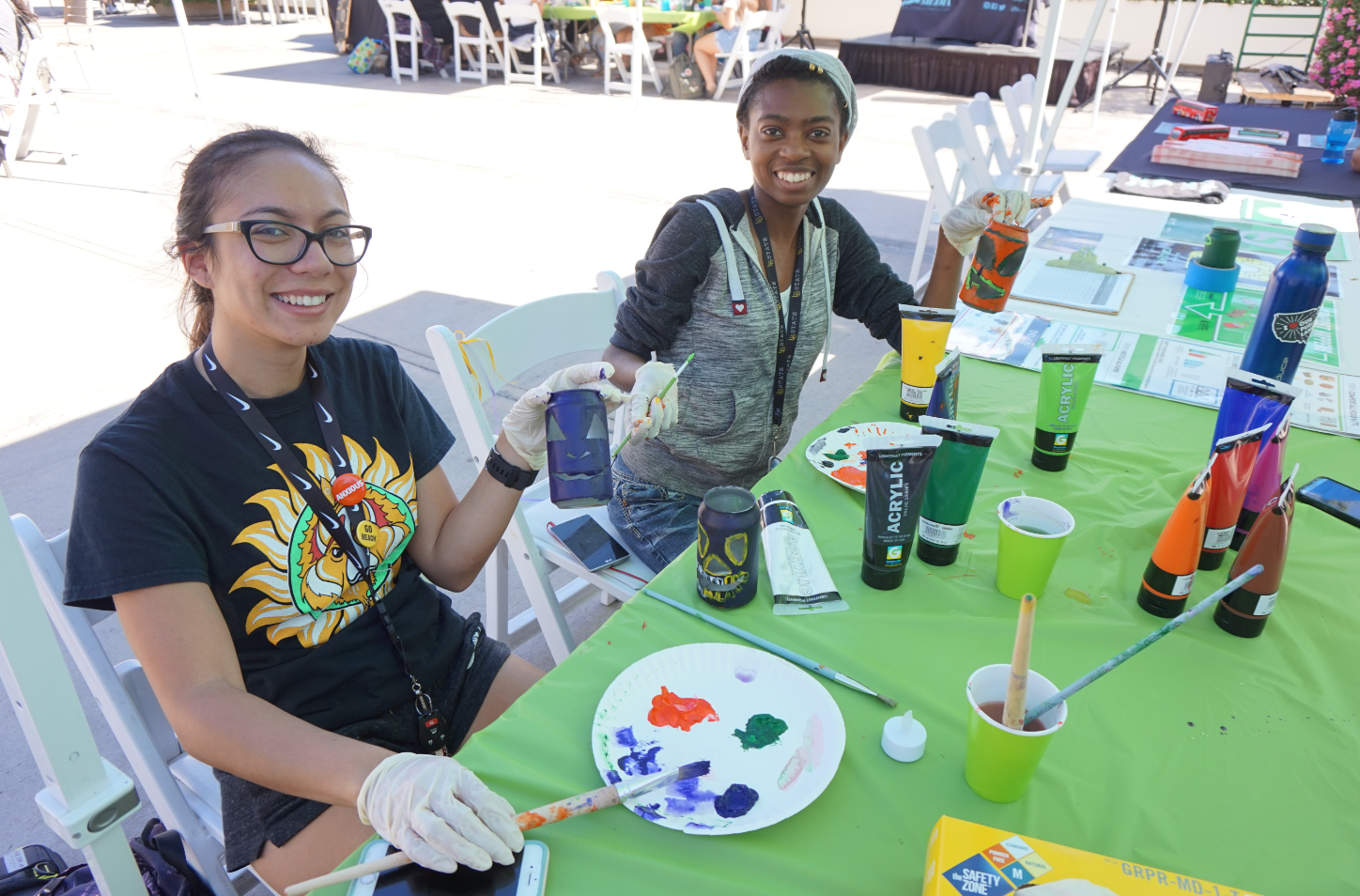 Girls painting metal cans