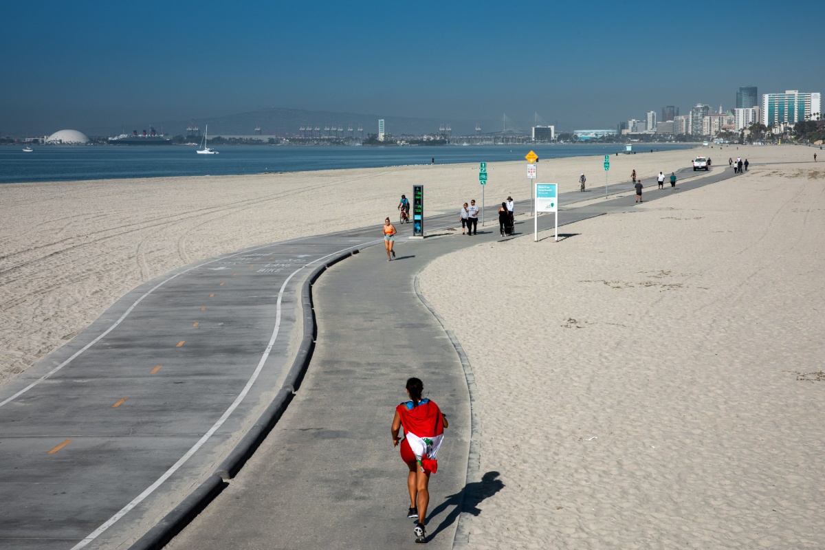 Clariza Ruiz de Castilla running on beach with flag.