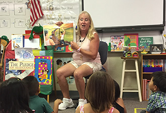 content_ced_big_story_2016-01-26_pelton.jpg Ms. Pelton reading a story book to kindergartners in English