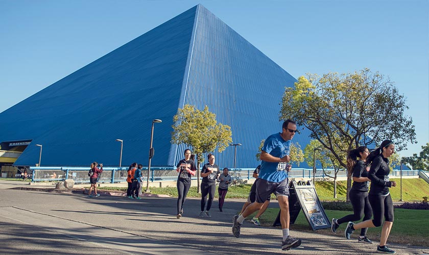 content_markcomm_breakingfronteras2.jpg Students running around the pyramid