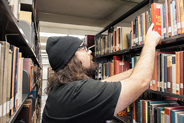 A man pulls a book from the shelf