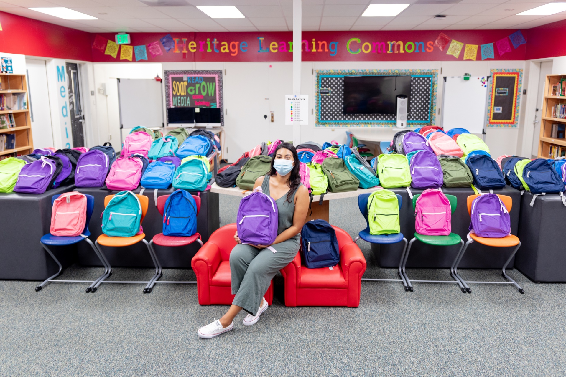 Eliza Castrejon in a classroom surrounded by backpacks