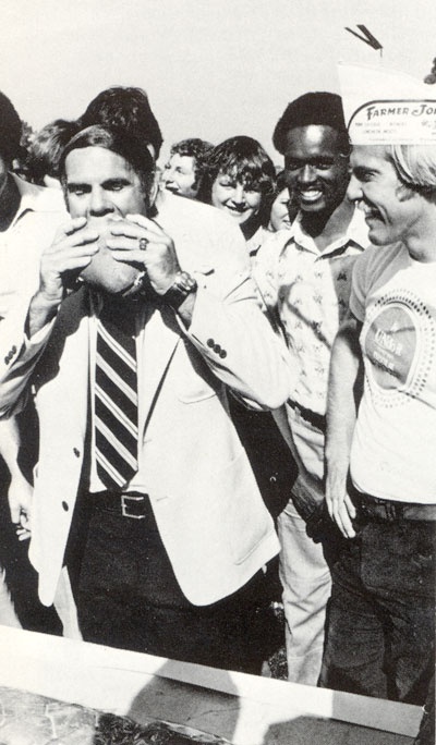 a man takes a large bite from the longest submarine sandwich