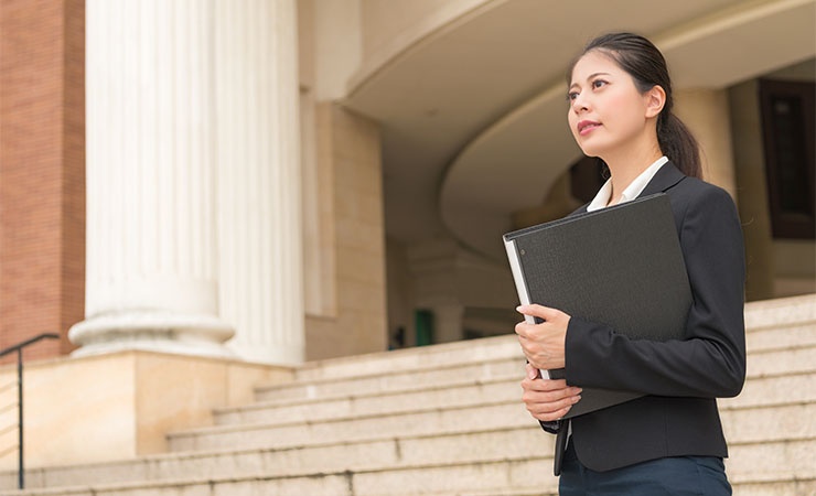 government_and_communities.jpg Female government worker standing outside courthouse