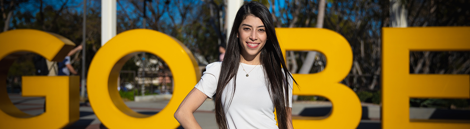 Student in front of Go Beach Sign