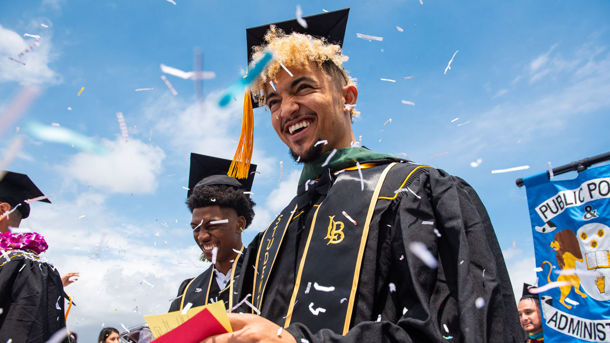 hero_comm19_chhs_02.jpg Two male graduates smile while confetti falls around them du