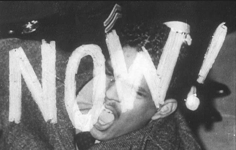 Photo of the word now with a man screaming behind