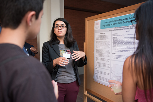 Maria Barajas practices presenting her poster at the BUILD S