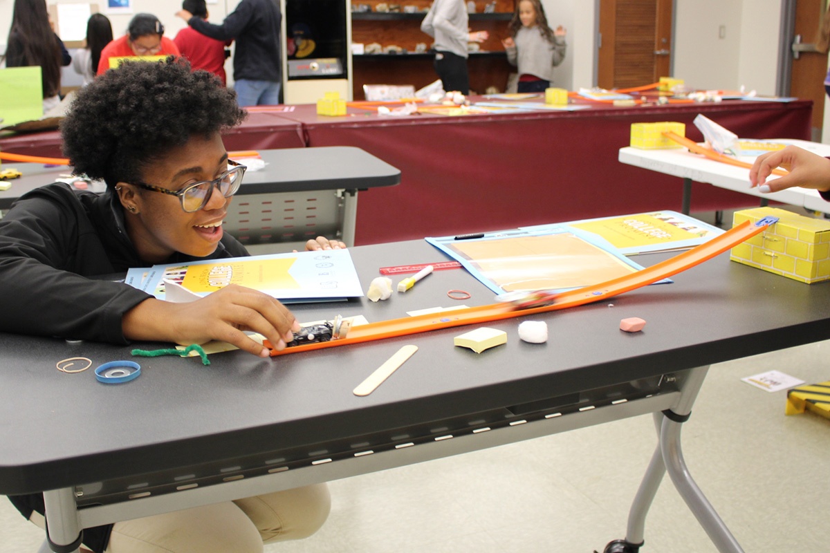 student experimenting with momentum transfer of toy cars