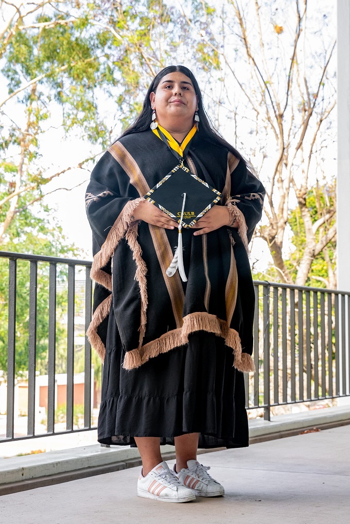 A person in traditional regalia poses at the 2022 Native Ame