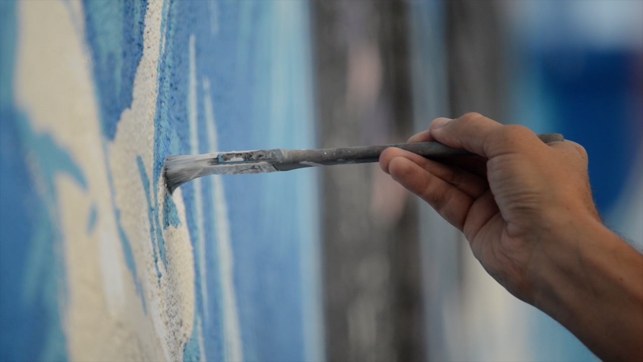 Hand painting a mural.